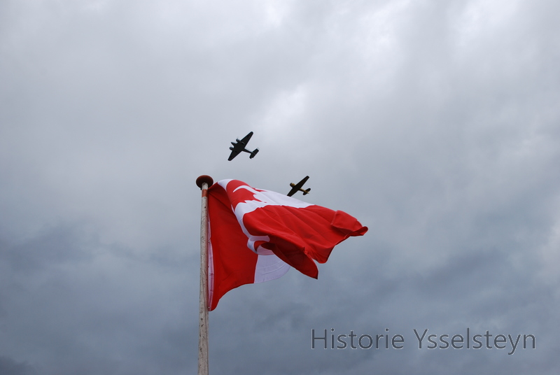 De twee vliegtuigen boven de Canadese vlag.