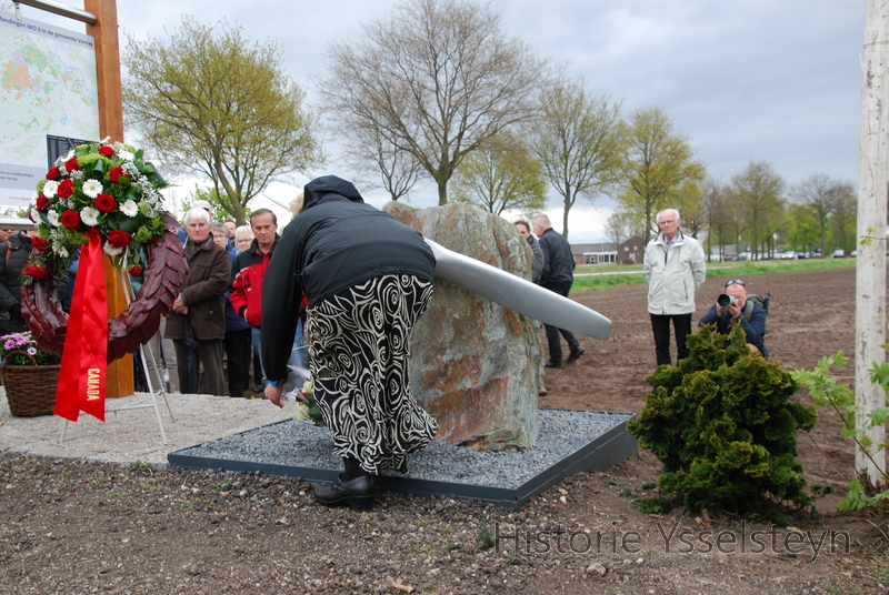 Tara Coulter legt bloemen bij het monument.