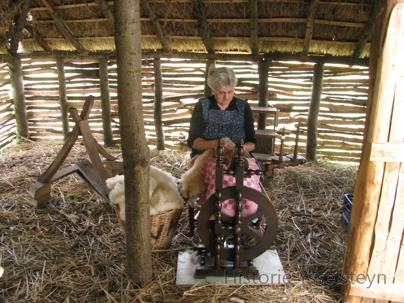 Riet Michels, vrijwilligster bij Museum De Peelstreek, aan het wol spinnen in de nagebouwde schaapskooi.