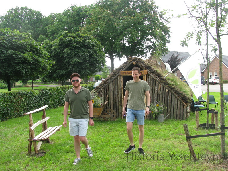 Twee bezoekers aan de plaggenhut.